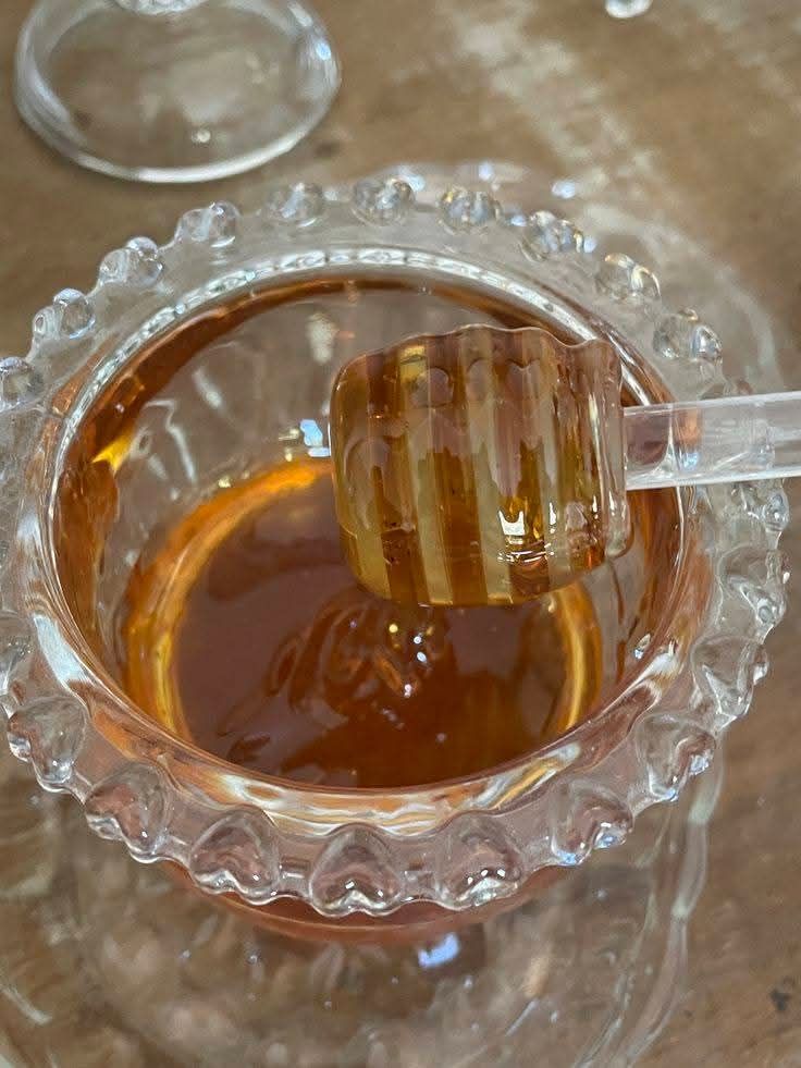 Dark golden Chhoti Makki honey served in a crystal bowl with dipper